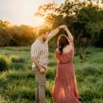 A couple gracefully dancing in a field at sunset, perfect for Valentine's Day.